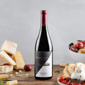 Pinot Noir bottle, surrounded by baby potatoes, fire roasted cherry tomatoes, pasta, and Parmesan cheese